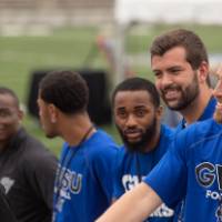 Guests on the field shaking hands at the Jamie Hosford Football Center dedication.
